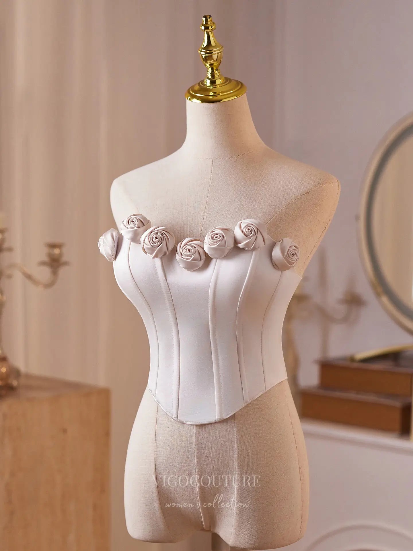 White corset with floral embellishments on a mannequin in an elegant room.